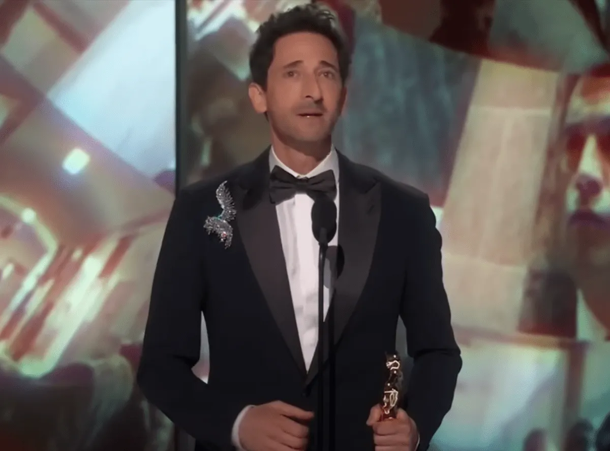 Wearing a black tuxedo and diamond lapel pin, Adrien Brody gives his Best Actor acceptance speech at the 2025 Academy Awards