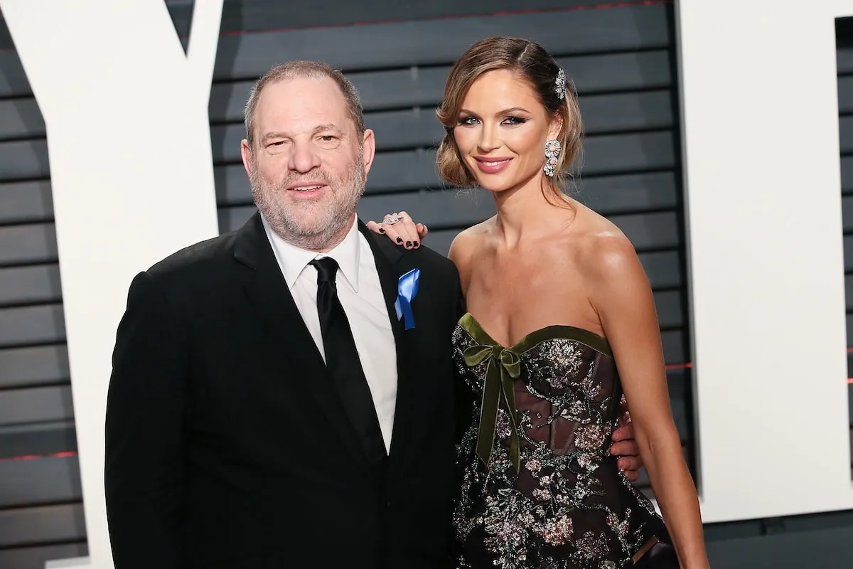 Wearing a tuxedo and black gown respectively, Harvey Weinstein and Georgina Chapman smile at the 2017 Vanity Fair Oscar Party